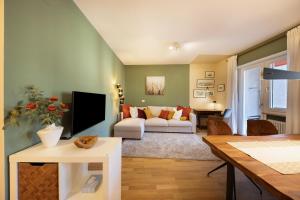 Una sala de estar con un sofá y un televisor. en Apartment Huita, en Bolzano