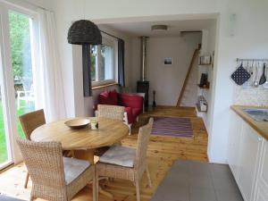 a kitchen and dining room with a wooden table and chairs at Strandhaus am Oberuckersee in Warnitz