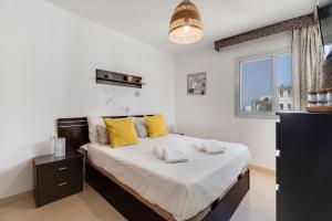 Un dormitorio con una cama grande con almohadas amarillas. en Apto Sol Paraiso Sunset View, en Adeje 24 fotos más