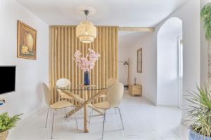 une salle à manger avec une table avec des chaises et un vase de fleurs dans l'établissement El Rincón de Hugo, à Alcalá de los Gazules
