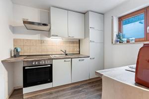 a kitchen with white cabinets and a sink and a window at Ferienwohnung Frieda in Wehr