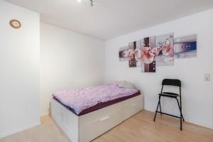 a small bedroom with a bed and a chair at Ferienwohnung Frieda in Wehr