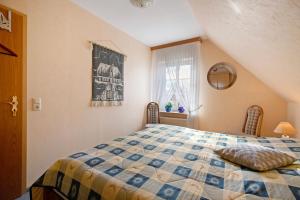 メルドルフにあるHaus Ellenのベッドルーム(キルト付きのベッド付)