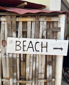 ein Schild mit der Aufschrift „Strand“ an einem Holzzaun in der Unterkunft UTOPIA in Gili Air