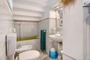 a bathroom with a toilet and a sink and a tub at Il giardino di Belgirate in Belgirate +14 photos