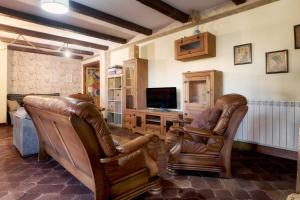 San Andrés del RabanedoにあるArroyo del Valleのリビングルーム(革張りの椅子2脚、テレビ付)