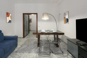 a living room with a table and a blue couch at Casa Laberio by Hili in Rome
