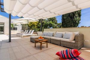 a patio with a couch and an umbrella at Hort Petit de Ternelles in Pollença