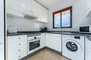 a white kitchen with a washing machine in it at Sea Views Torreoceano 7 in Mijas Costa