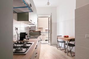 a kitchen with a stove and a table with chairs at Casa Laberio by Hili in Rome