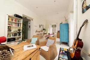Una sala de estar con una mesa y sillas y una guitarra. en Hostal Vidamia, en Málaga