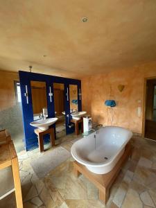 a large bathroom with a tub and two sinks at Separate Area mit Schlafzimmer und Badezimmer in Heroldsberg
