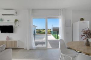 sala de estar con mesa, sillas y puerta corredera de cristal en Casa Sofia, en Roche