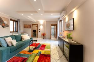 a living room with a blue couch and a colorful rug at La Terrazza House in Lanciano