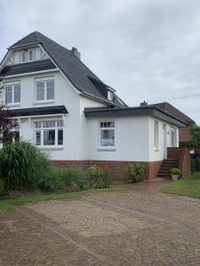 a white house with a black roof at Ferienwohnung Alte Liebe in Cuxhaven