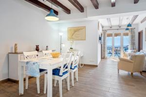 een witte eetkamer met een witte tafel en stoelen bij Loft Jb in L'Ametlla de Mar
