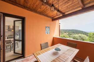 Un comedor con una mesa y una vista de una cocina. en Casa vacanza Porto Luna Villasimius, en Villasimius