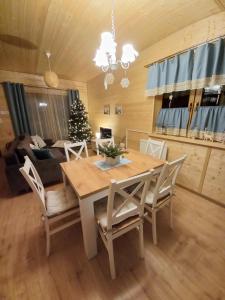 クドヴァ・ズドゥルイにあるDomek Luna Wilcza Zagrodaのダイニングルーム(テーブル、椅子、クリスマスツリー付) +15枚の写真