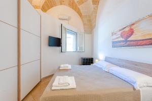 une chambre avec un lit et une télévision sur un mur dans l'établissement San Giorgio Apartment, à Cavallino di Lecce