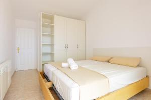 a white bedroom with a large bed with white cabinets at Villa Grau in Canet de Mar