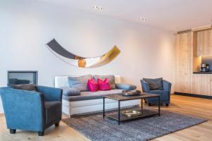 un salon avec un canapé, deux chaises et une table dans l'établissement Aura Chalets - Nr 3, à Castelrotto