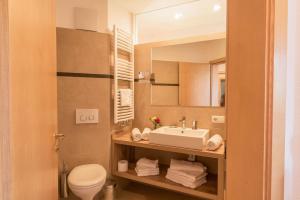 a bathroom with a sink and a toilet and a mirror at Apartment Sella - Unterkehrhof in Laion +15 photos
