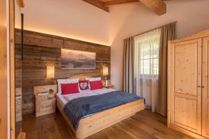 a bedroom with a bed and a wooden wall at Apartment Sella - Unterkehrhof in Laion