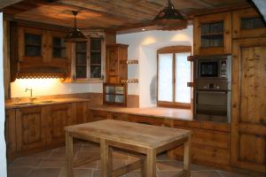 eine Küche mit Holzschränken und einem Holztisch in der Unterkunft La ferme des Fontany in Samoëns + 17 Fotos