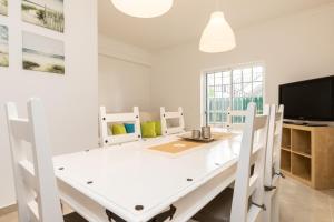 een witte eetkamer met een witte tafel en stoelen bij 10T2 by AlgarveManta in Manta Rota