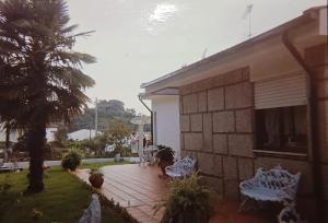 a patio with two white chairs and a house at Casa da Luisinha in Amarante