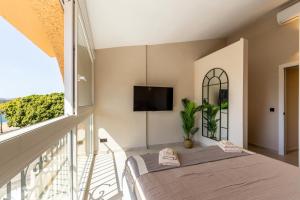 a bedroom with a bed and a balcony with a tv at Casa Eva in Estepona +37 photos