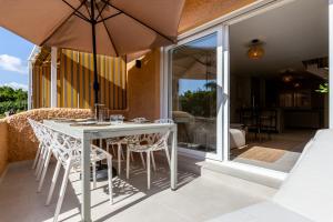 a white table with chairs and an umbrella on a patio at Casa Eva in Estepona
