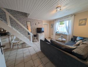 Una sala de estar con un sofá y una escalera. en Ferienwohnungen-im-Koog, en Wesselburenerkoog