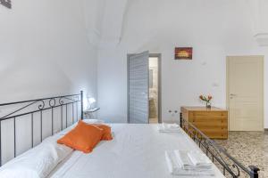 a bedroom with a bed with an orange pillow on it at Dimore degli innamorati in Presicce