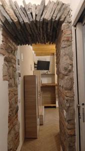 Zimmer mit einer Steinmauer und einem Kühlschrank in der Unterkunft la meridiana lago maggiore 2 in Laveno-Mombello