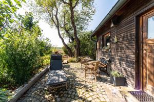 un patio avec des chaises et une table à côté d'un bâtiment dans l'établissement Naturnahe Ferienwohnung Deuerling, à Deuerling