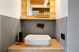 a bathroom with a white sink on a wooden counter at Bio Maso Nido Verde in Frassilongo +23 photos