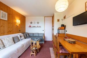 a living room with a couch and a table at Appartement Le Creux de l'Ours in Méribel