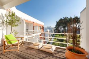 MarinhasHino à Natureza - T2 em Condomínio的一座建筑里的阳台,配有椅子和植物