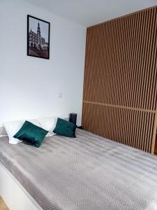 a bedroom with a bed with two green pillows at Apartament Anna przy Starówce in Zamość +9 photos