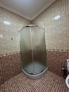 a glass shower in a bathroom with a sink at Triumph Comfort in Astana