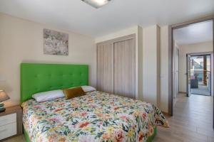 una camera da letto con un letto con testiera verde di Numar Residence A A a Vila Nova de Cacela Altre 23 foto