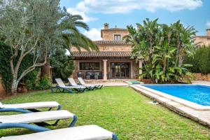 a yard with lounge chairs and a swimming pool at Casa Brava in Santanyi