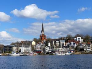 BehrendorfにあるAltes Landhausの水上に船があり教会がある街