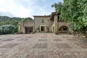 a large stone house with a large driveway at Can Tapis in Santa María de Camós