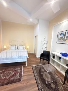 a bedroom with a white bed and a black chair at St Martin Apartment in Vienna