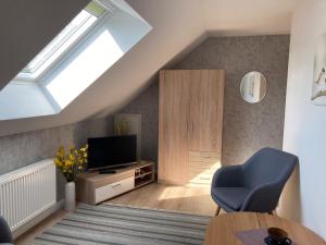 a living room with a tv and a blue chair at Ferienhaus Lisa in Wolmersdorf