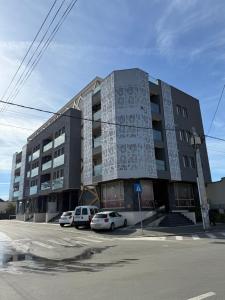 ein großes Gebäude, vor dem Autos parken in der Unterkunft Studio One Cassas Residence in Craiova