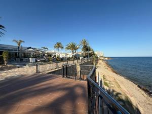 a sandy beach with palm trees and the ocean at Casa Eveline in Punta Prima
