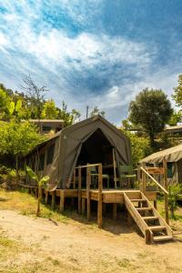ein Zelt mit einem Bett und einer Treppe davor in der Unterkunft Safari Glamping Portugal Flamingo in Ventosa